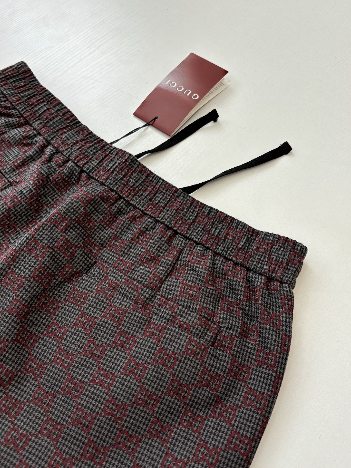 Gucci patterned pants with elastic waistband and drawstring ties, folded