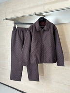 Gucci jacket and matching pants set on hangers, maroon and dark allover patterned fabric.