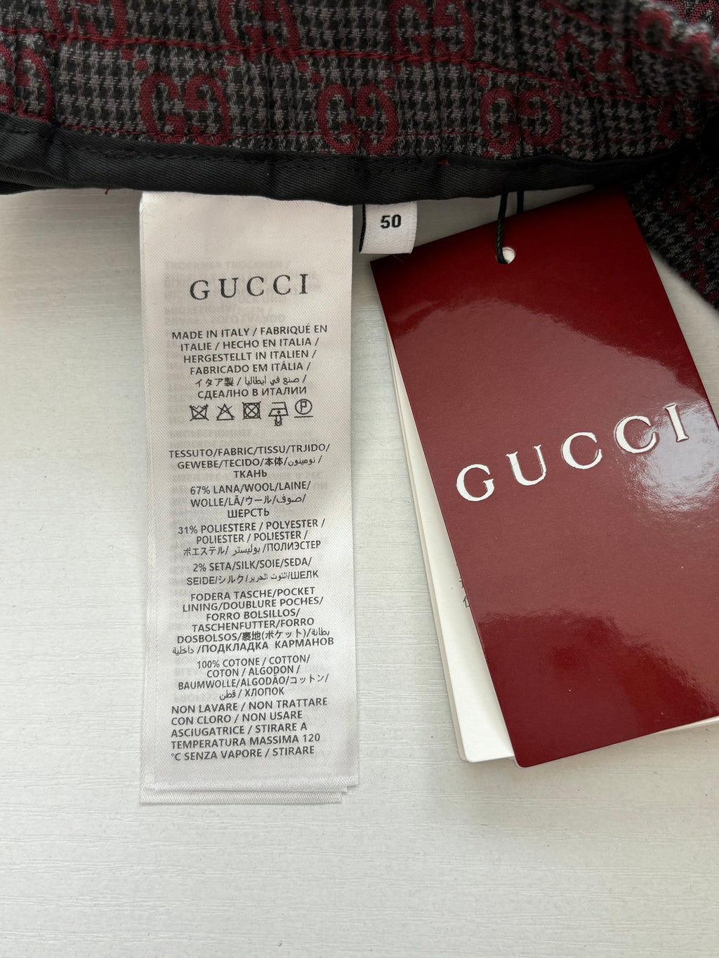 Long clothing care label with size tag and Gucci branded hang tag