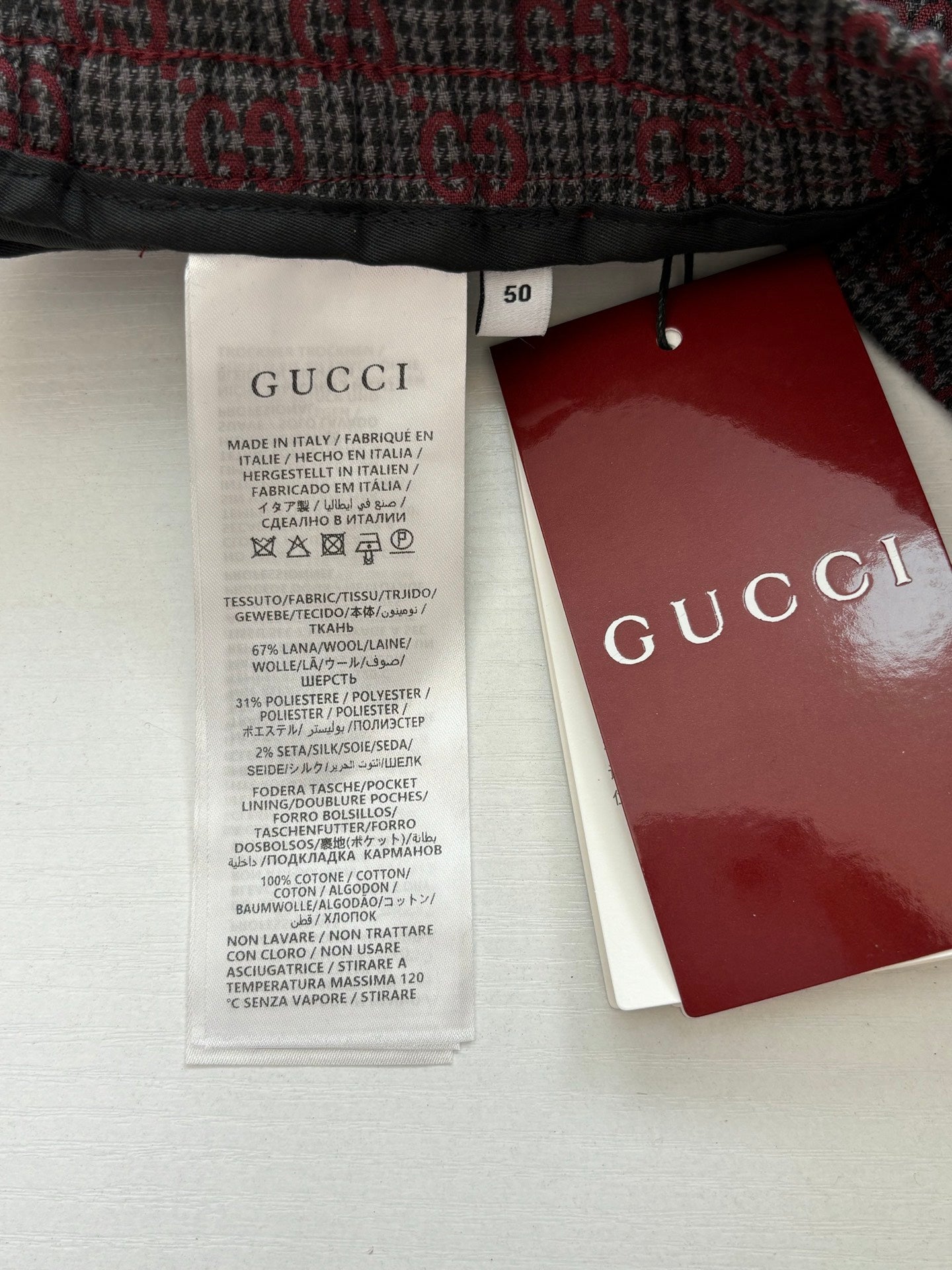 Long clothing care label with size tag and Gucci branded hang tag