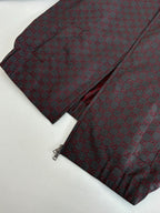 Gucci jacket sleeve and pants folded together, maroon and dark patterned fabric.