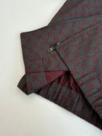 Gucci pants front and jacket detail, maroon and dark patterned fabric with button closure.