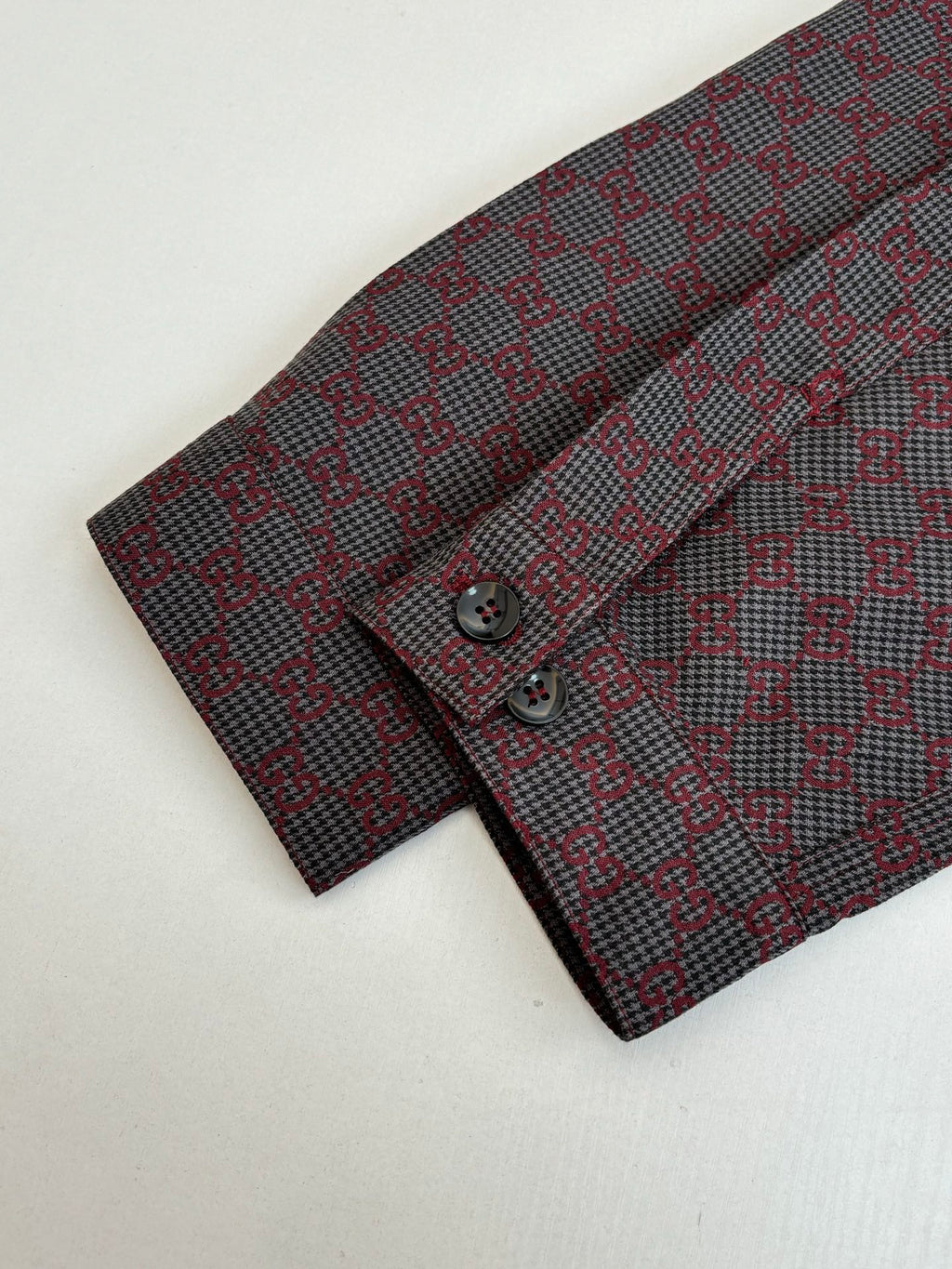 GG-pattern button-up shirt cuff with button and placket, red and gray