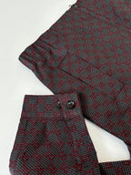 Gucci patterned jacket sleeve and pants, maroon and dark fabric with dense motif print.