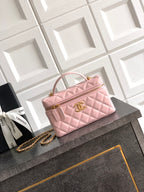 Light pink quilted bag with top handle and gold-tone chain strap, front flap closure