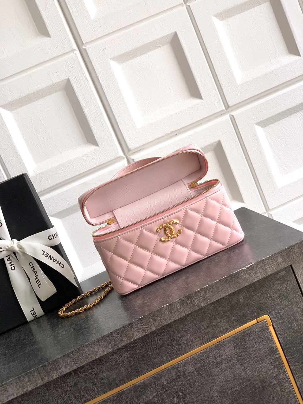 Light pink quilted bag with open flap, gold-tone chain strap and top zipper closure