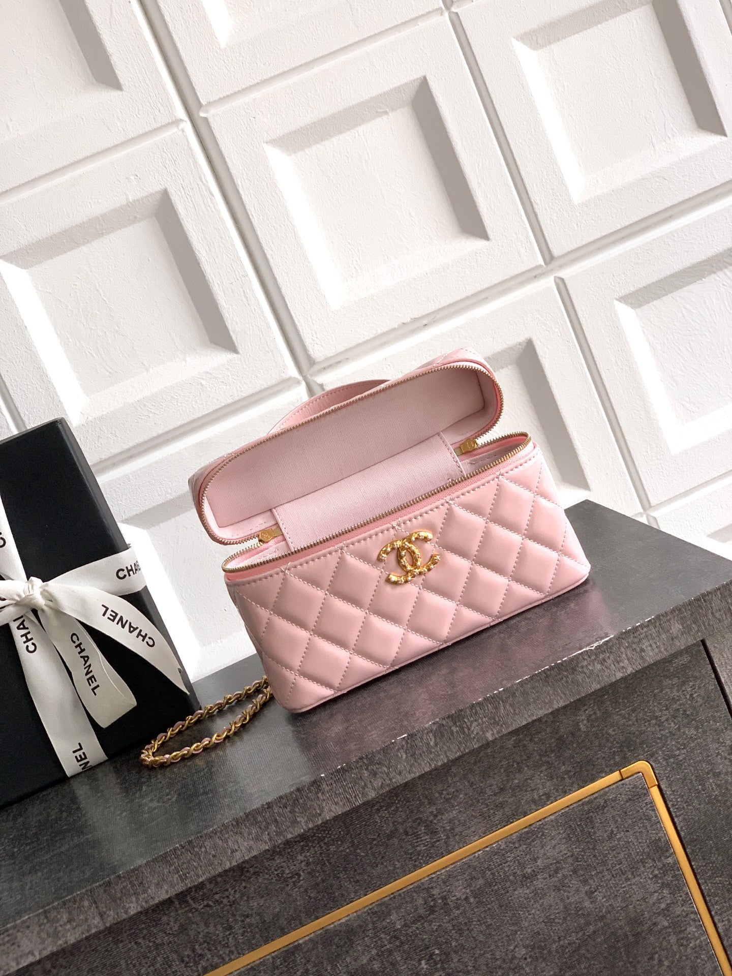 Light pink quilted bag with open flap, gold-tone chain strap and top zipper closure