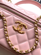Light pink quilted leather bag close-up of gold-tone CC logo and zipper