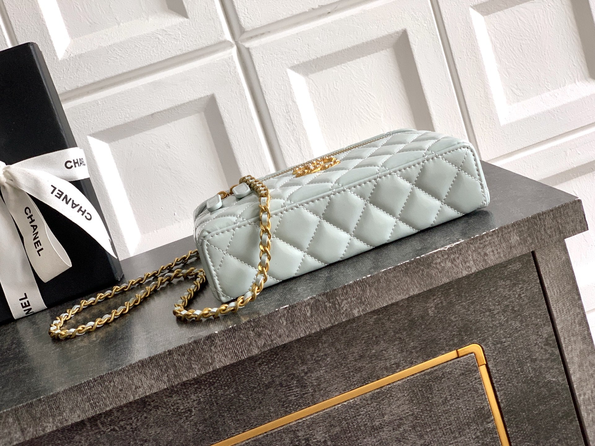 Light blue Chanel quilted bag with gold chain strap and top handle