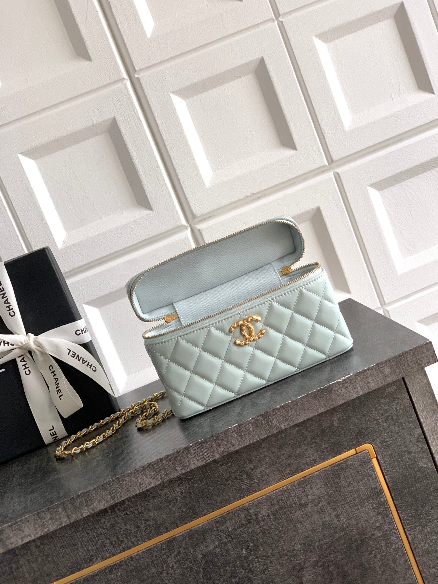 Light blue Chanel quilted bag with gold zipper and structured top handle