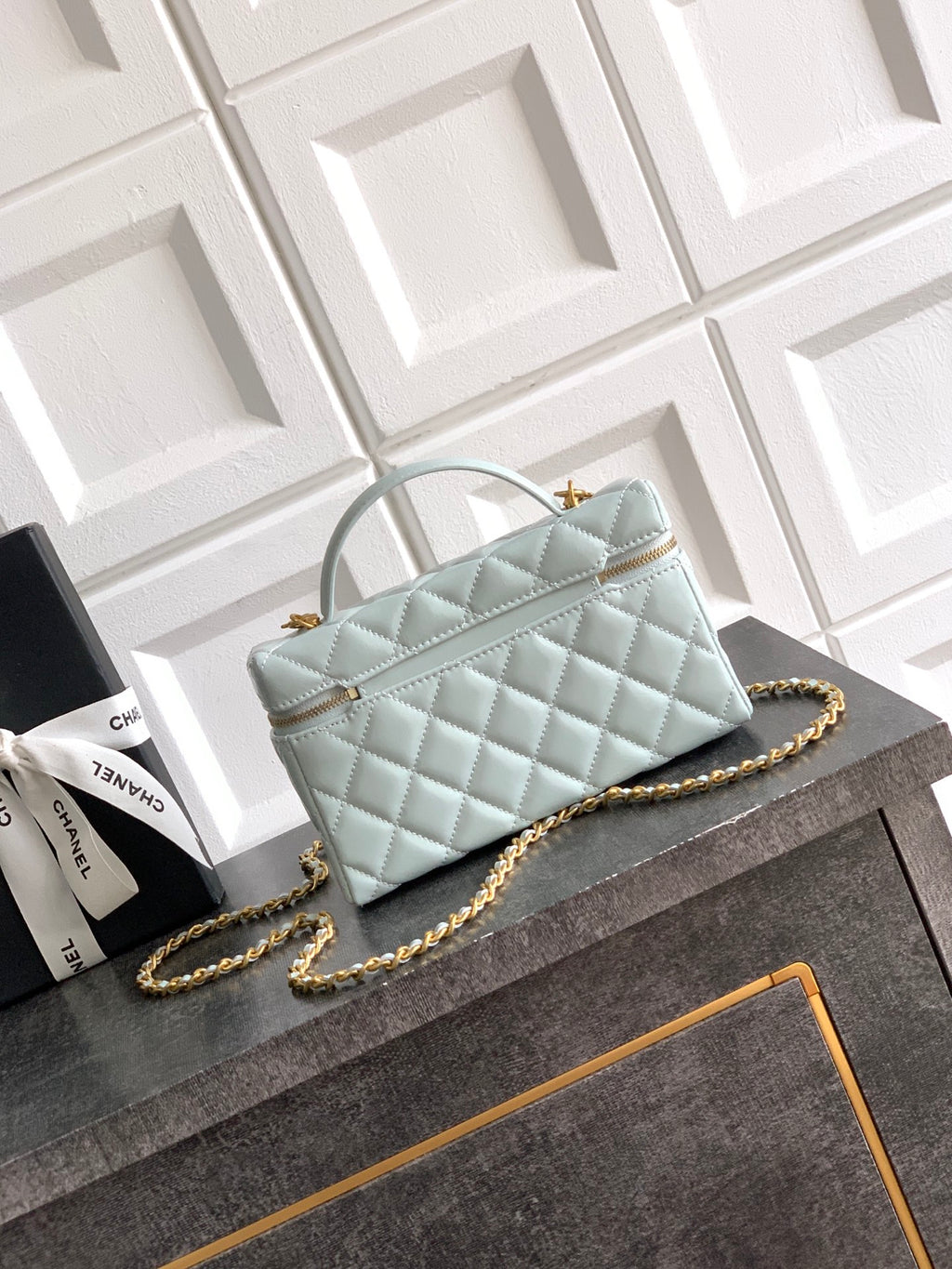 Light blue Chanel quilted top-handle bag with gold chain crossbody strap