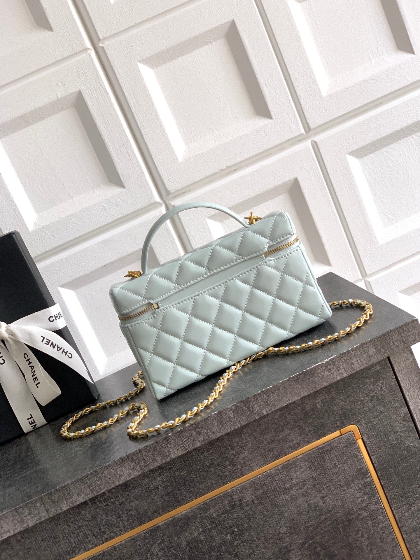 Light blue Chanel quilted top-handle bag with gold chain crossbody strap