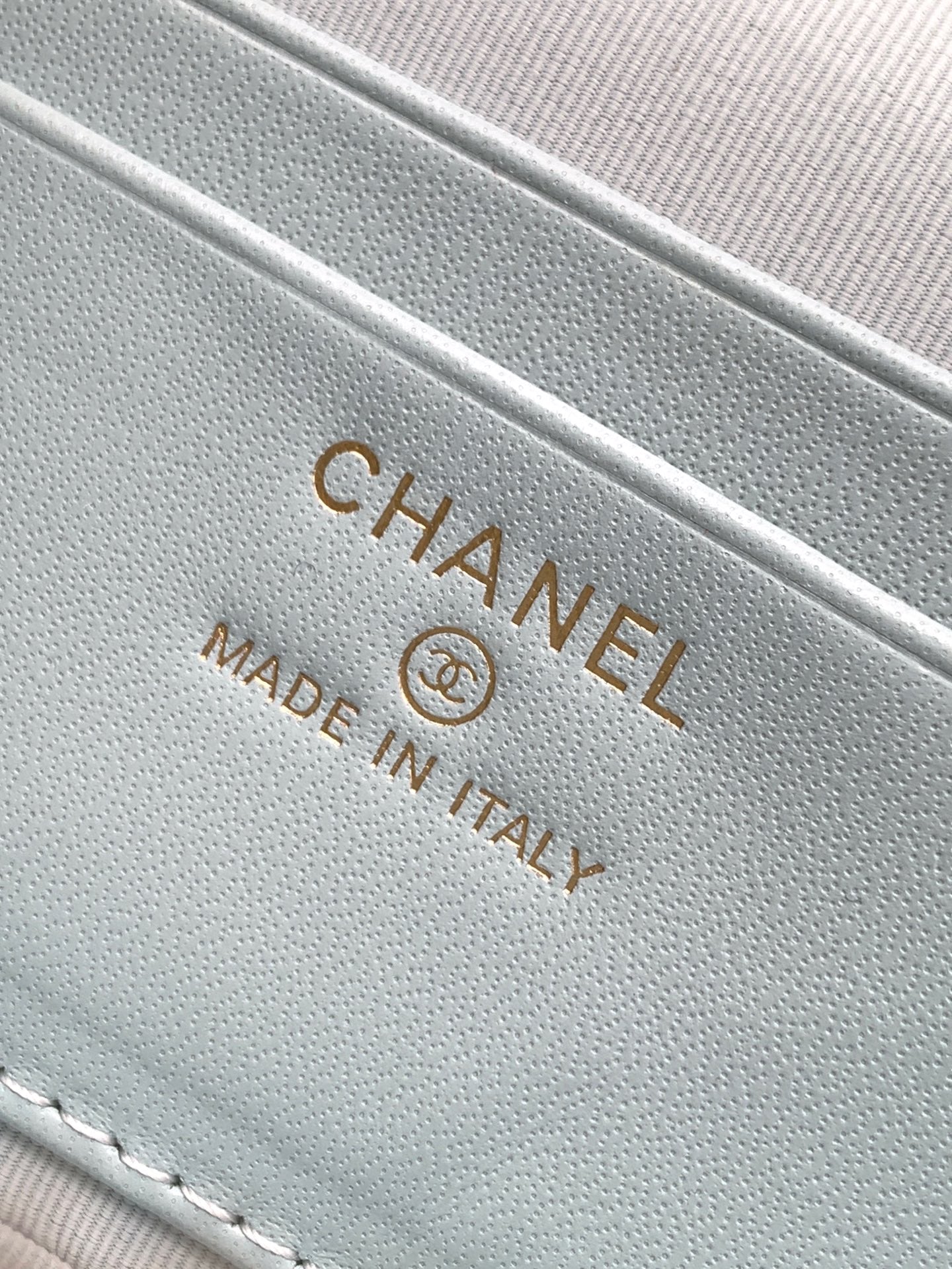 Light blue Chanel bag label reading "Made in Italy" on fabric lining