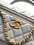 Chanel quilted bag detail, gold-tone CC emblem and zip pull on light silver-gray