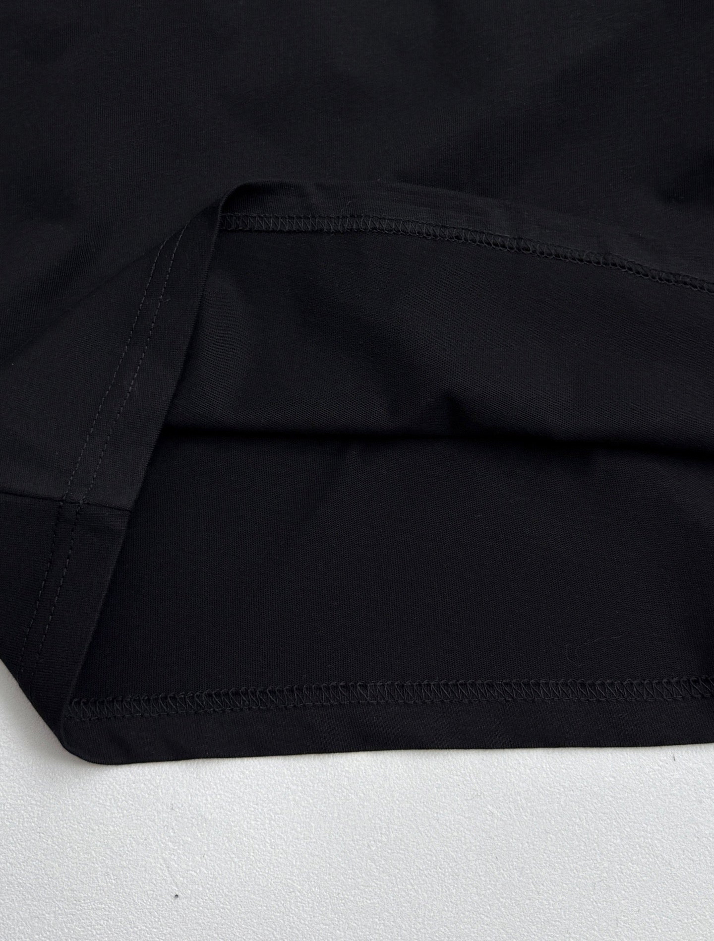 Louis Vuitton black T-shirt fabric with visible stitching at sleeve and body hem