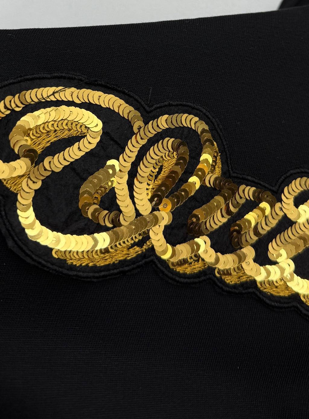 Louis Vuitton black T-shirt with gold sequin-style “Quiltn” graphic detail on chest