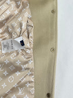 Beige jacket side panel with snap buttons and patterned lining edge detail.