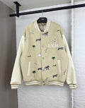Beige varsity jacket with animal and palm prints, ribbed cuffs, and button front detail.