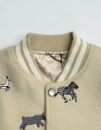 Beige knit jacket collar with striped ribbing and zebra patch detail near button placket.