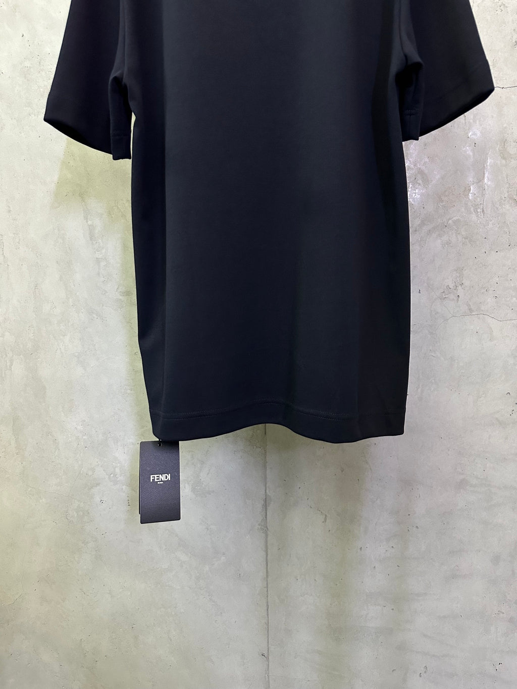 Dark navy T-shirt back with small FENDI tag hanging at the hem