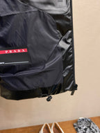 Black sleeveless puffer vest with PRADA label pocket and zipper trim.