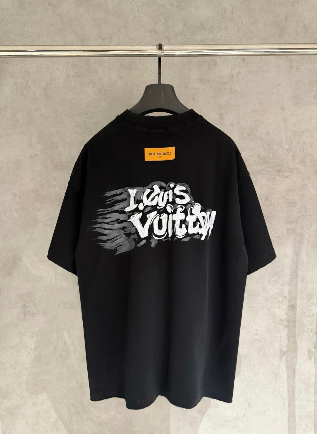 Black T-shirt with large white graffiti-style graphic on back.