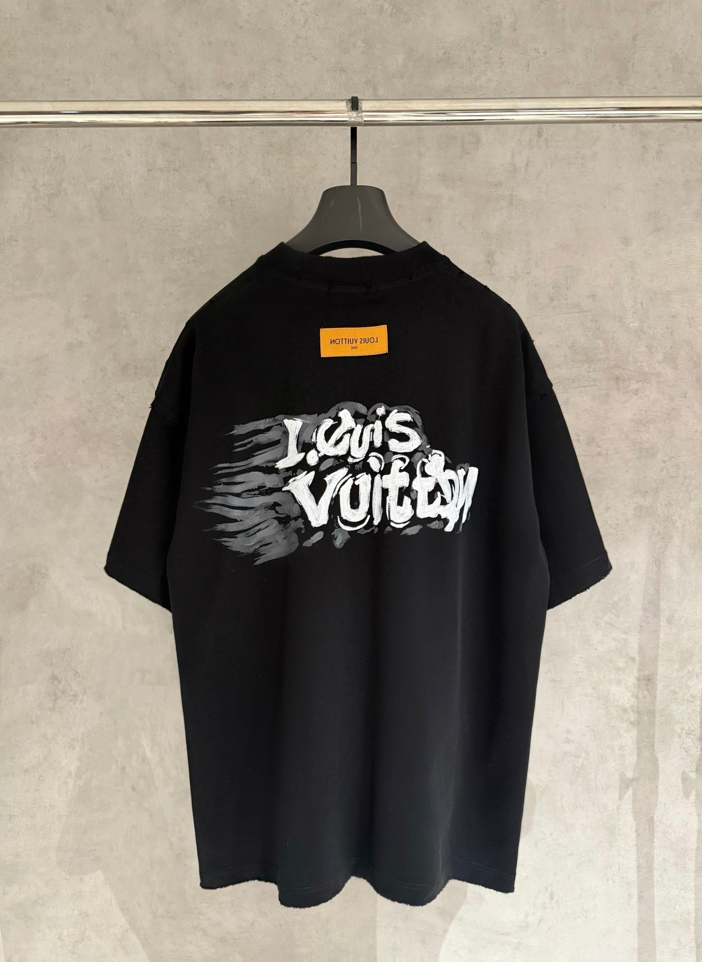 Black T-shirt with large white graffiti-style graphic on back.
