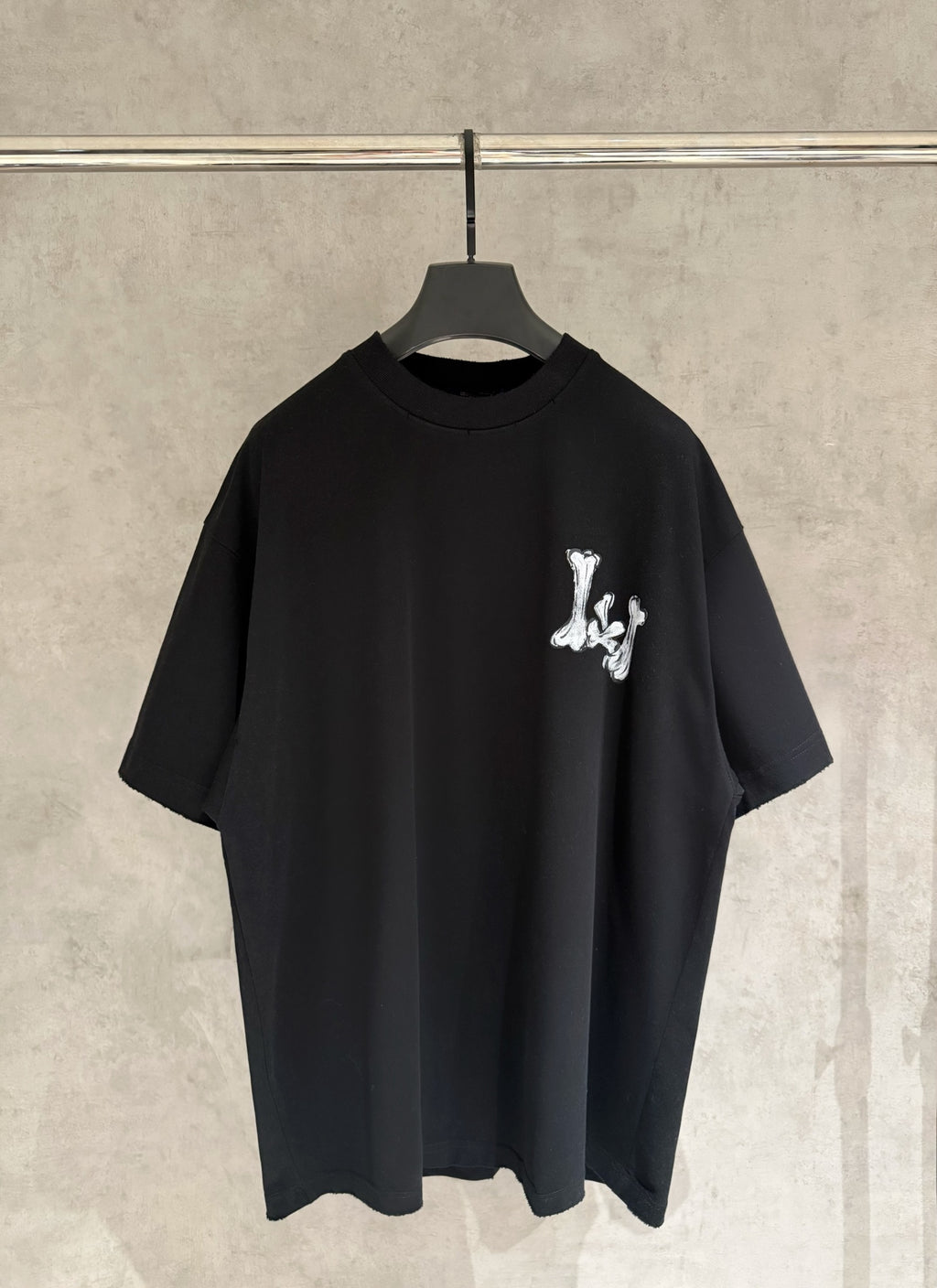 Black T-shirt with small white graphic logo on chest.