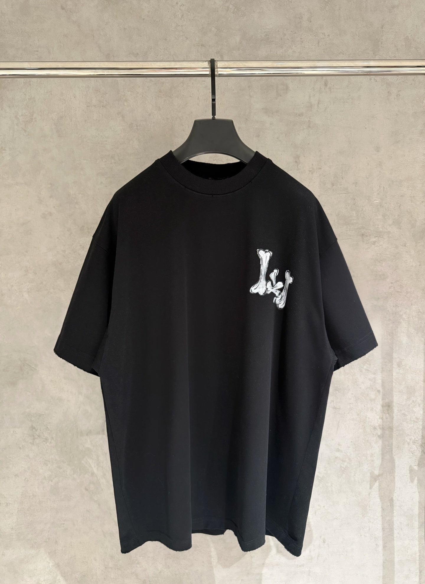 Black T-shirt with small white graphic logo on chest.