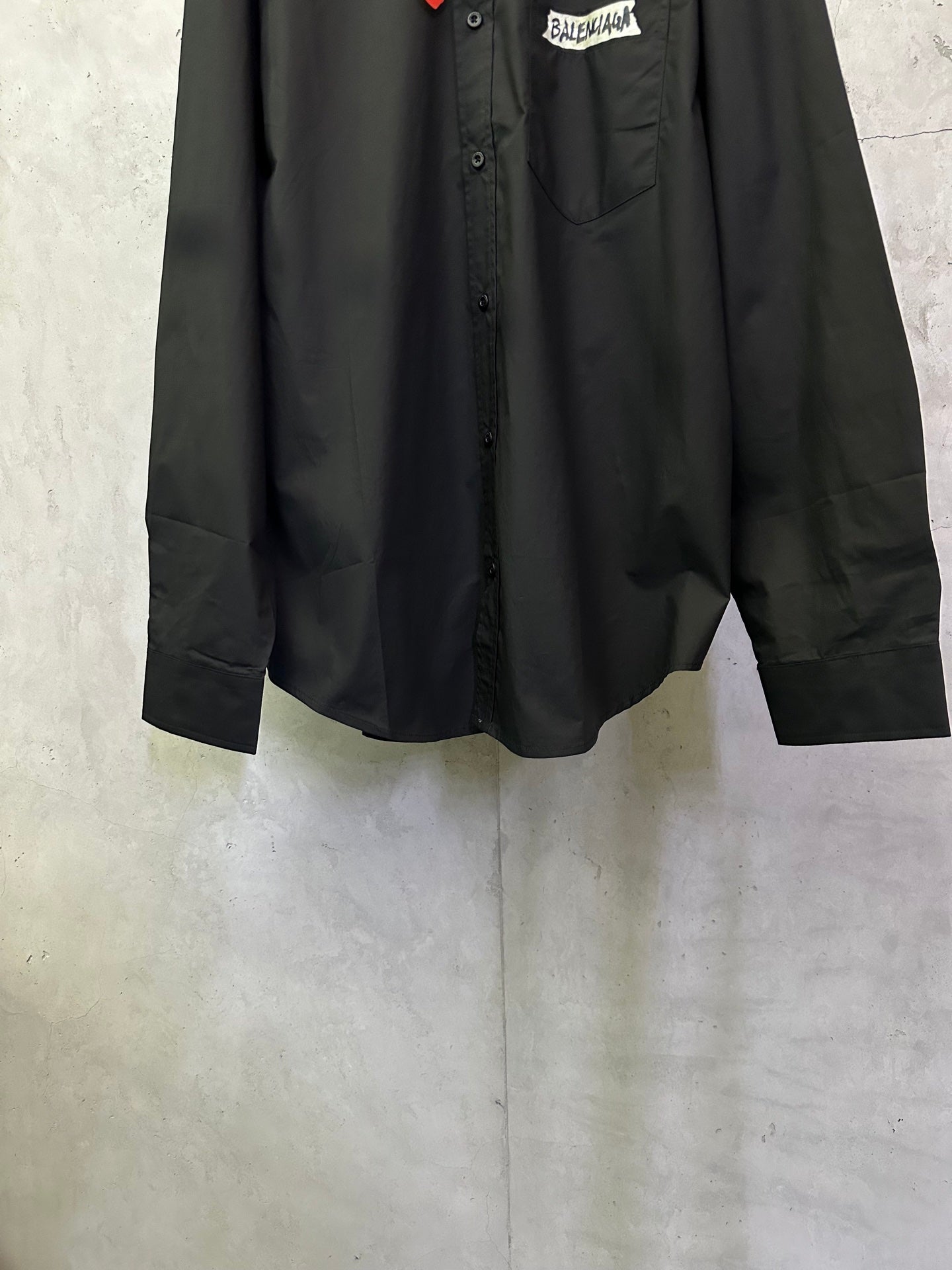 Balenciaga long-sleeve button-up shirt front, showing buttons and curved hem