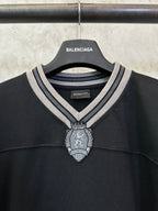 Black Balenciaga long-sleeve top neckline with striped trim and decorative crest