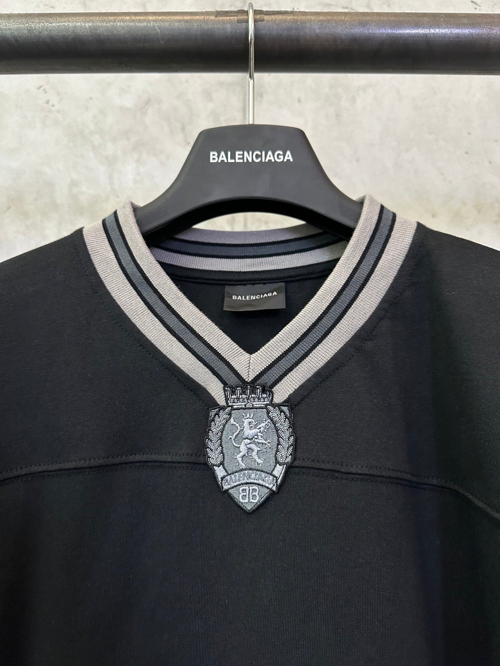Black Balenciaga long-sleeve top neckline with striped collar and metal crest charm