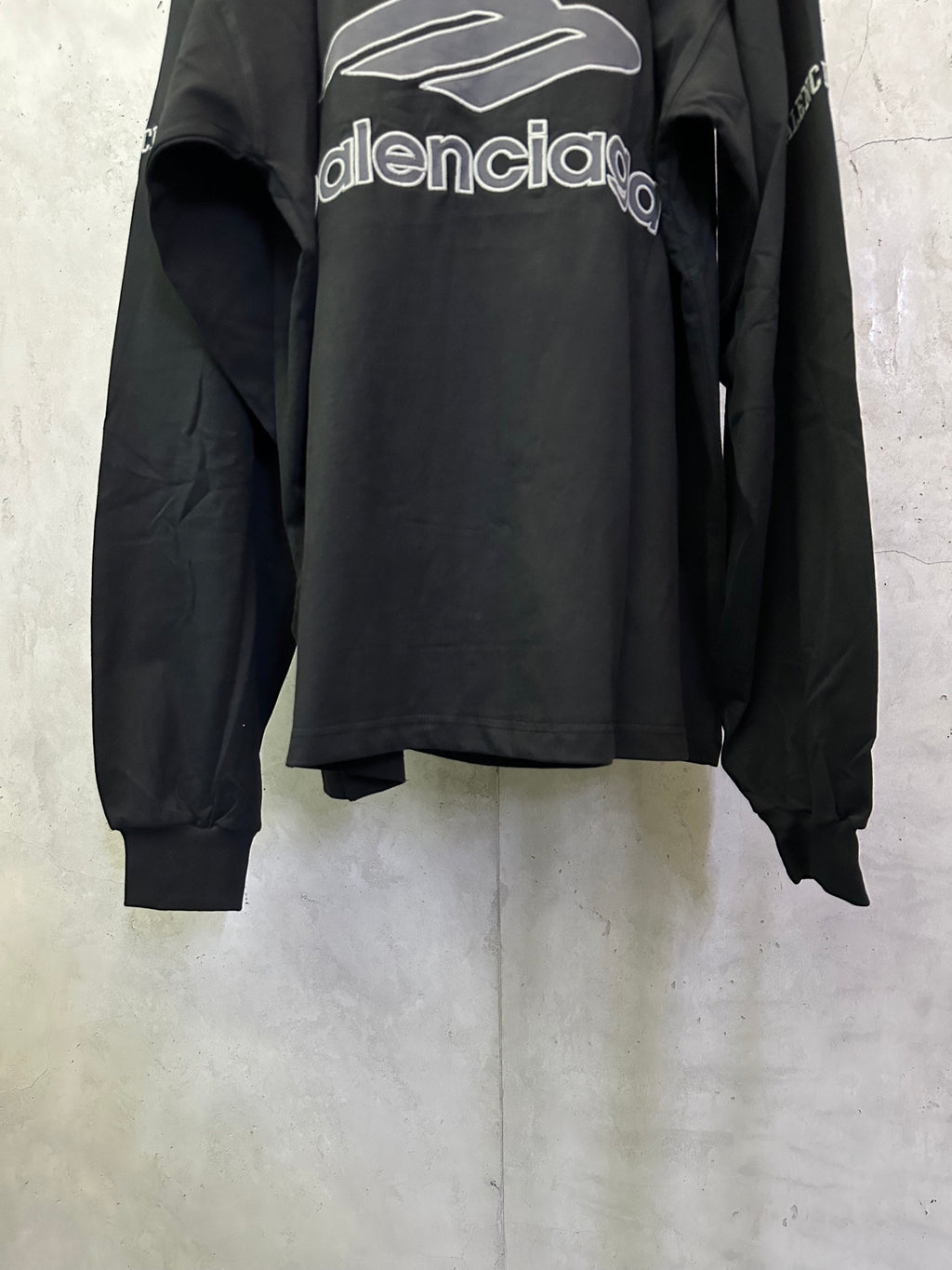 Black Balenciaga long-sleeve top, back view, with oversized front-to-back logo