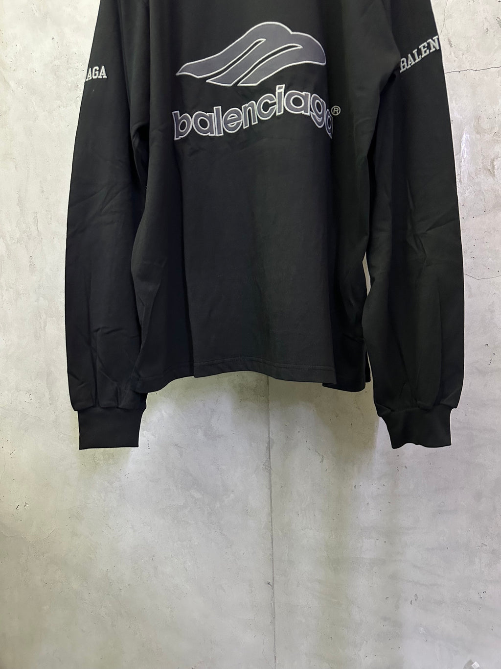 Black Balenciaga long-sleeve top front view with Balenciaga logo and ribbed cuffs