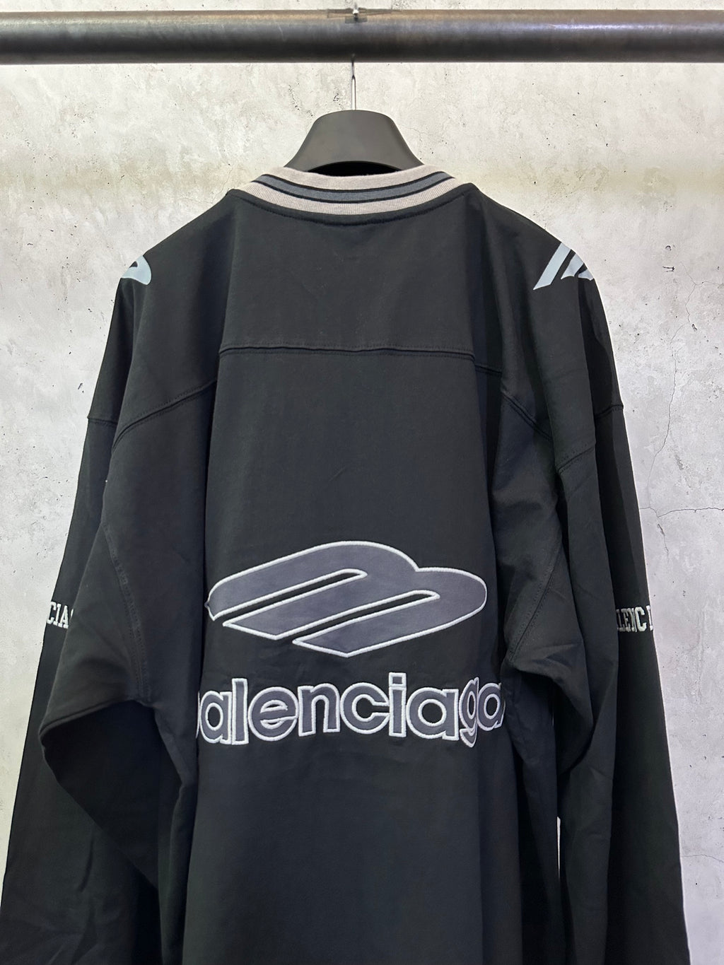 Black Balenciaga long-sleeve top with front logo graphic and striped V-neck collar