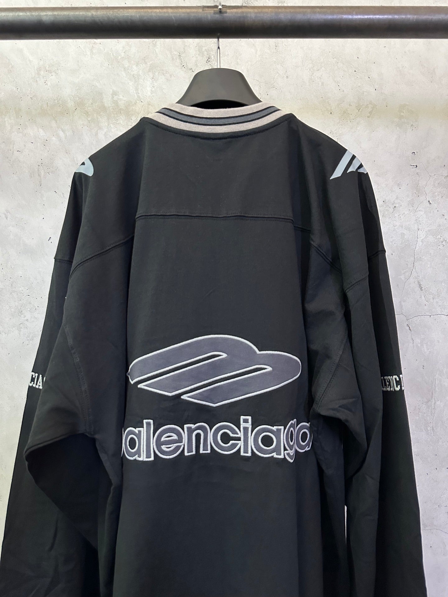 Black Balenciaga long-sleeve top with front logo graphic and striped V-neck collar