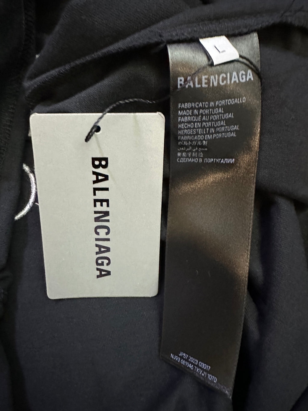 Balenciaga clothing label tag on dark fabric with size info and barcode