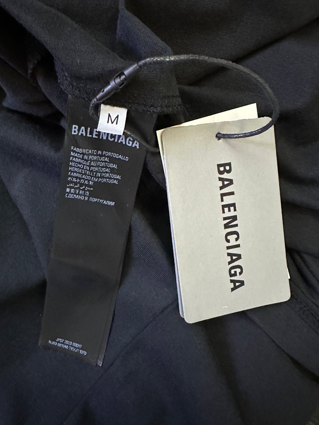 Black short-sleeve shirt with size M and fabric tags attached