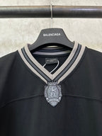 Balenciaga black V-neck jersey with striped collar and ornate hanging crest charm
