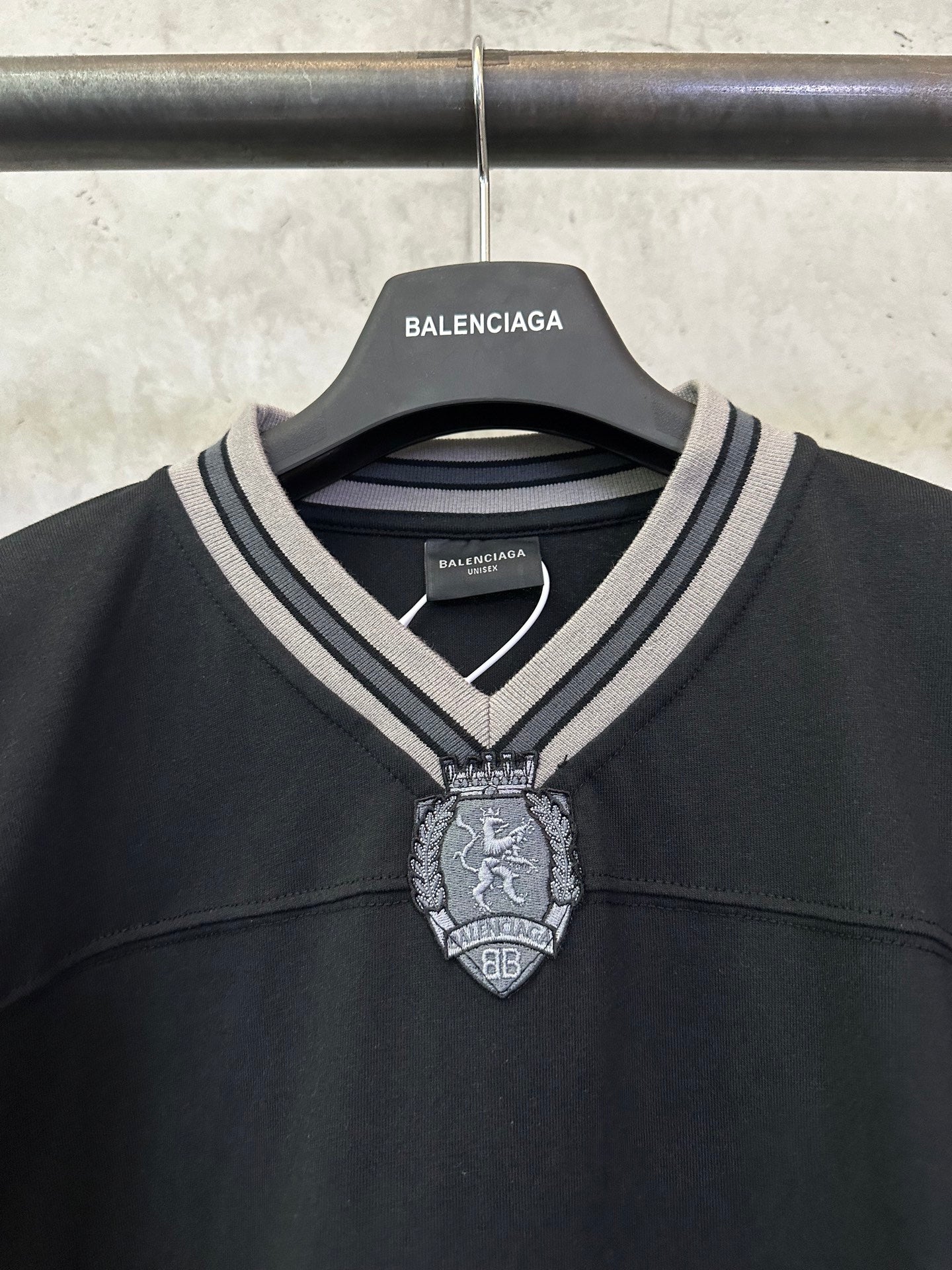Balenciaga black V-neck jersey with striped collar and ornate hanging crest charm
