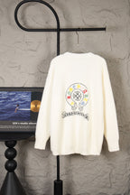 Cream fuzzy knit cardigan with colorful crest graphic on the back