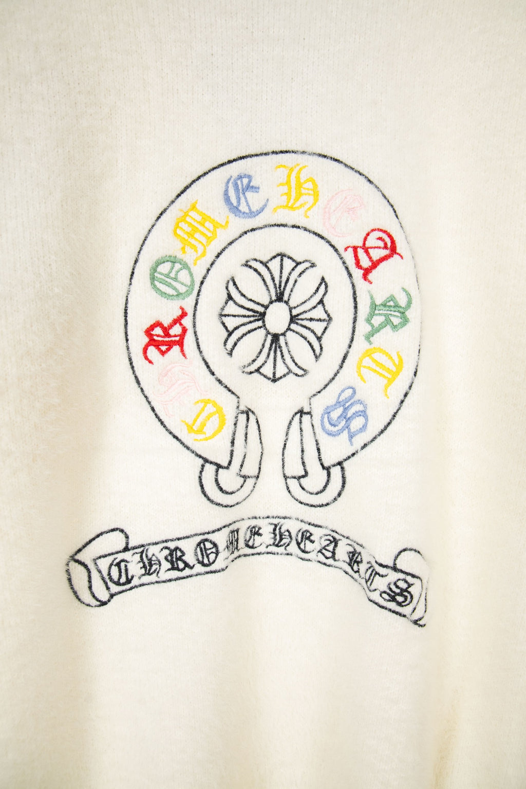 Cream knit cardigan with circular emblem and multicolor crest lettering
