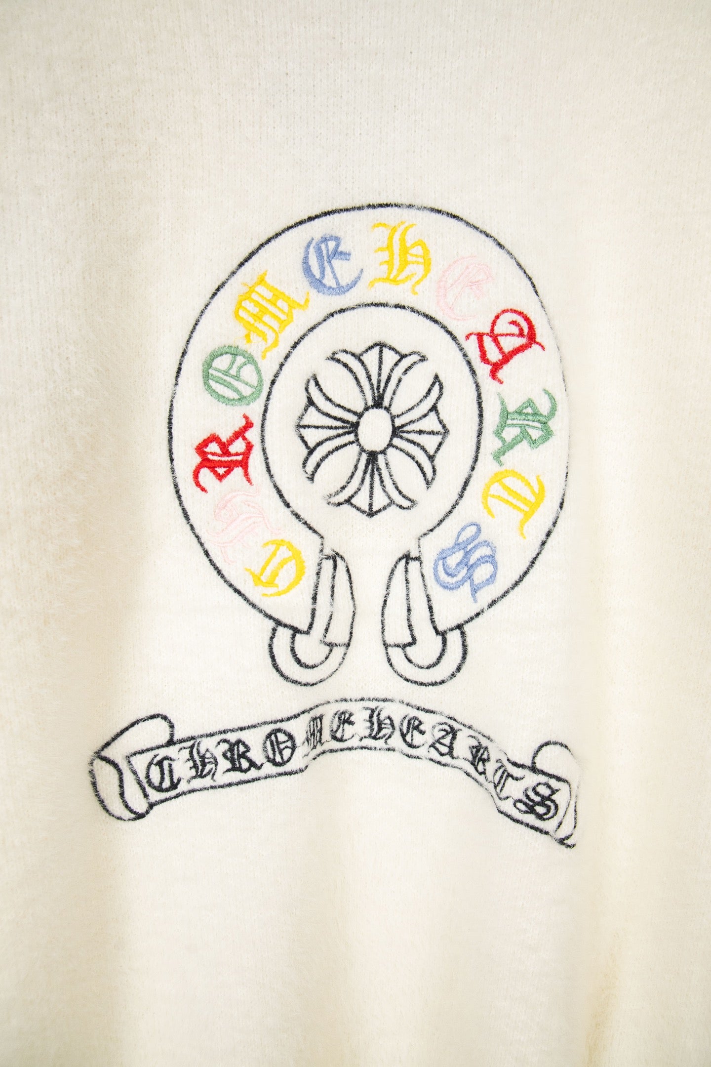Cream knit cardigan with circular emblem and multicolor crest lettering