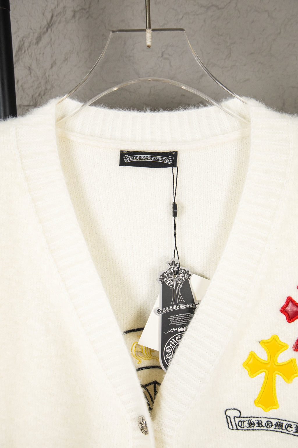 Cream knit cardigan with ribbed V-neck and inner brand label tag
