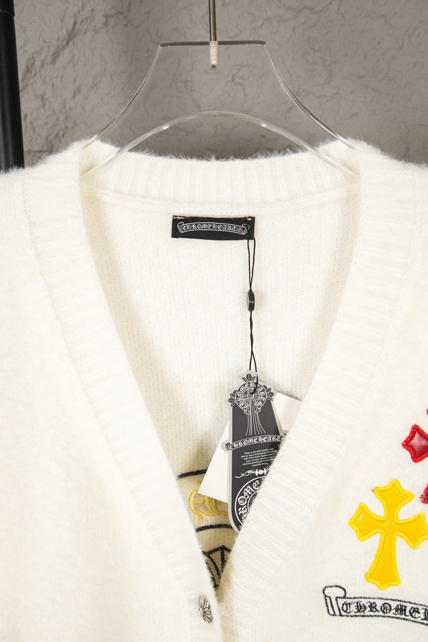 Cream knit cardigan with ribbed V-neck and inner brand label tag
