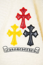 Cream knit cardigan with red, yellow, and black cross appliqués