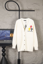 Cream fuzzy knit cardigan with button front and cross-and-flower emblem