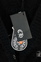 Black cardigan with attached gray hang tag showing white logo symbol