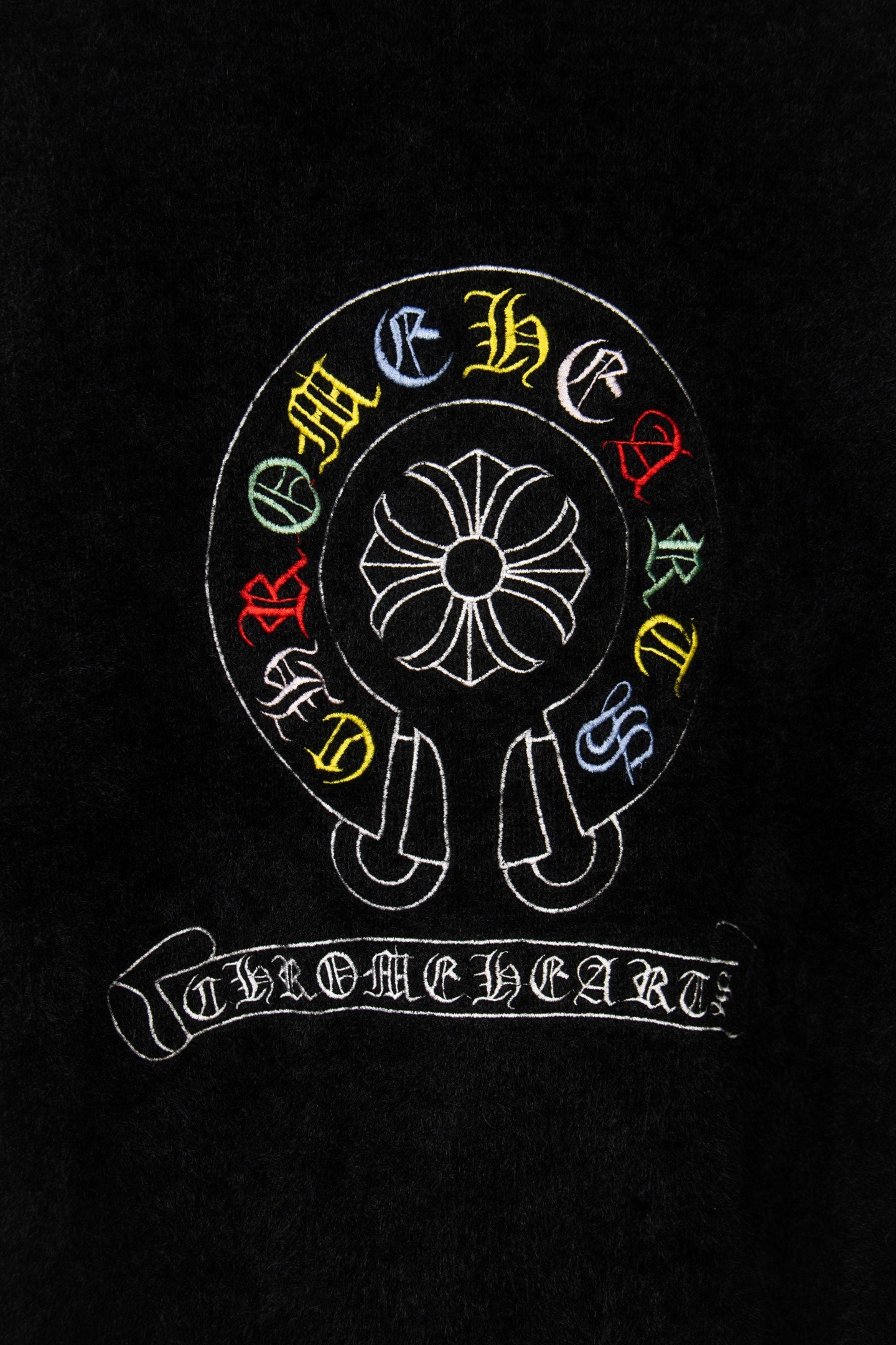 Black cardigan back with large circular emblem and arched embroidered text