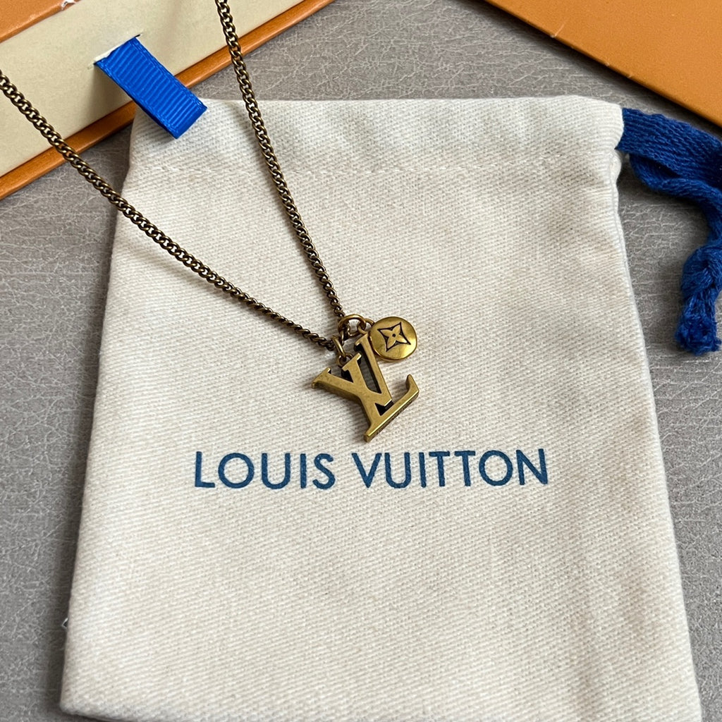 Louis Vuitton gold LV pendant necklace on chain, shown over white pouch